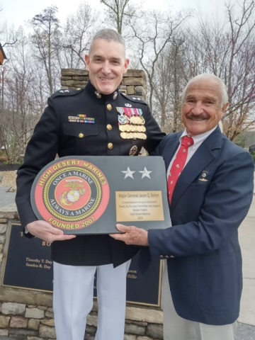 Two customers holding a personalized Marine plaque
