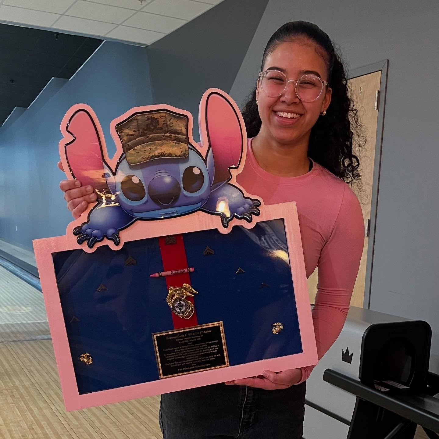 Customer holding a pink Stitch-themed Marine shadow box