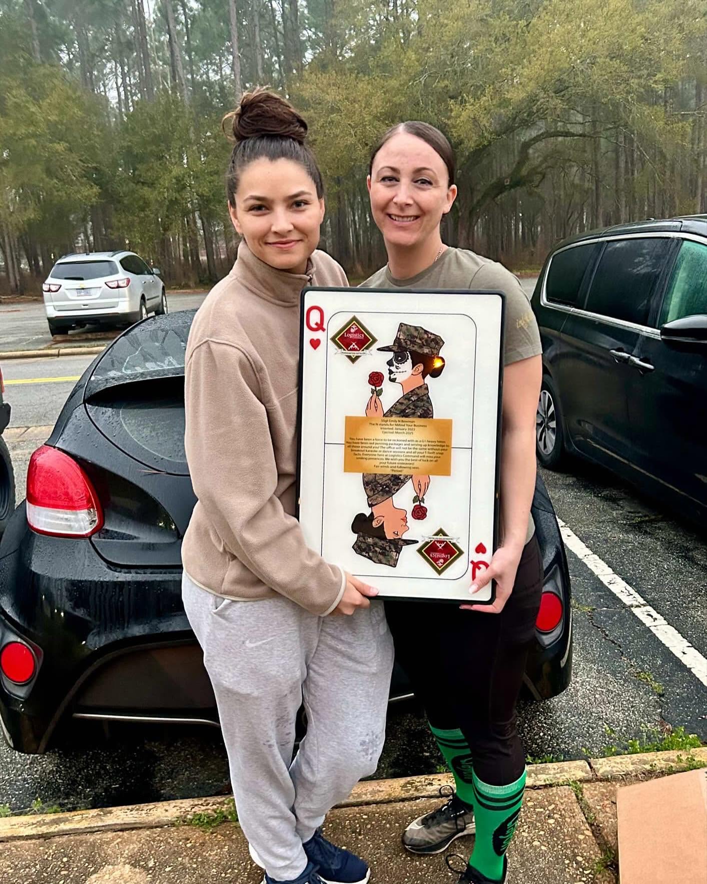 Two customers holding a Queen of Hearts Marine plaque