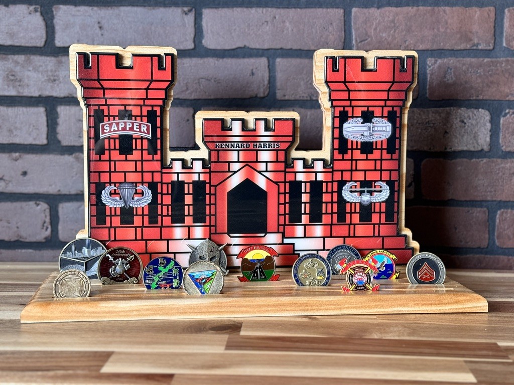 Personalized red castle-shaped challenge coin display on a wooden base