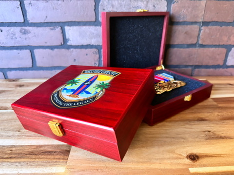 Two red wooden medal boxes, one open with medals inside
