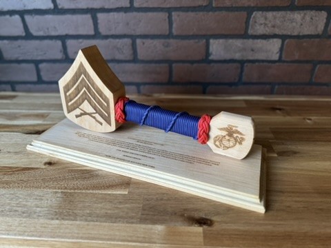 Rank-shaped wood hammer with blue and red cord on an engraved base