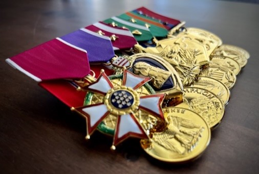 Mounted full-size military medals with colorful ribbons and polished gold finishes