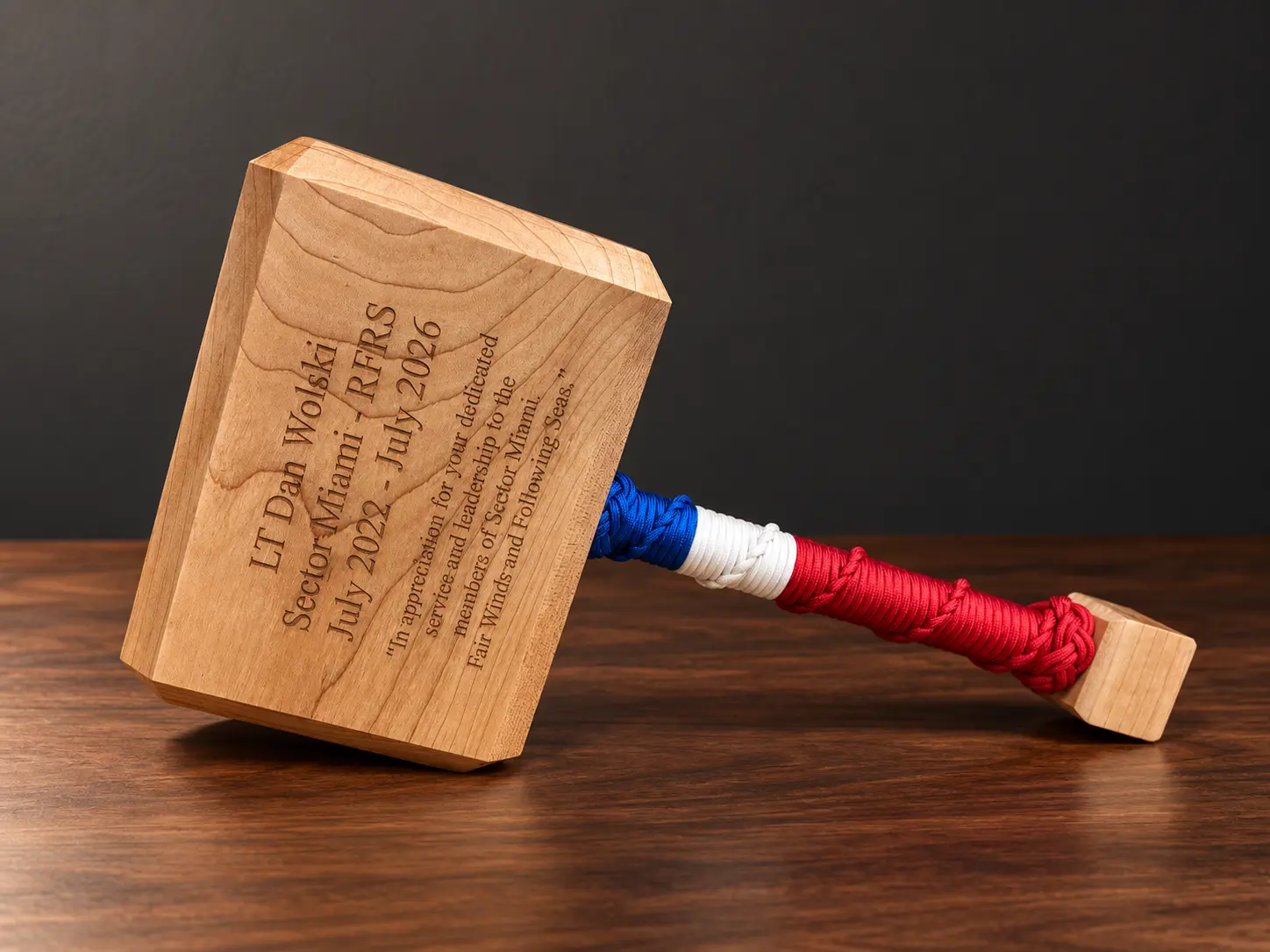 Angled view of a maple Thor hammer with engraved name, dates and retirement message